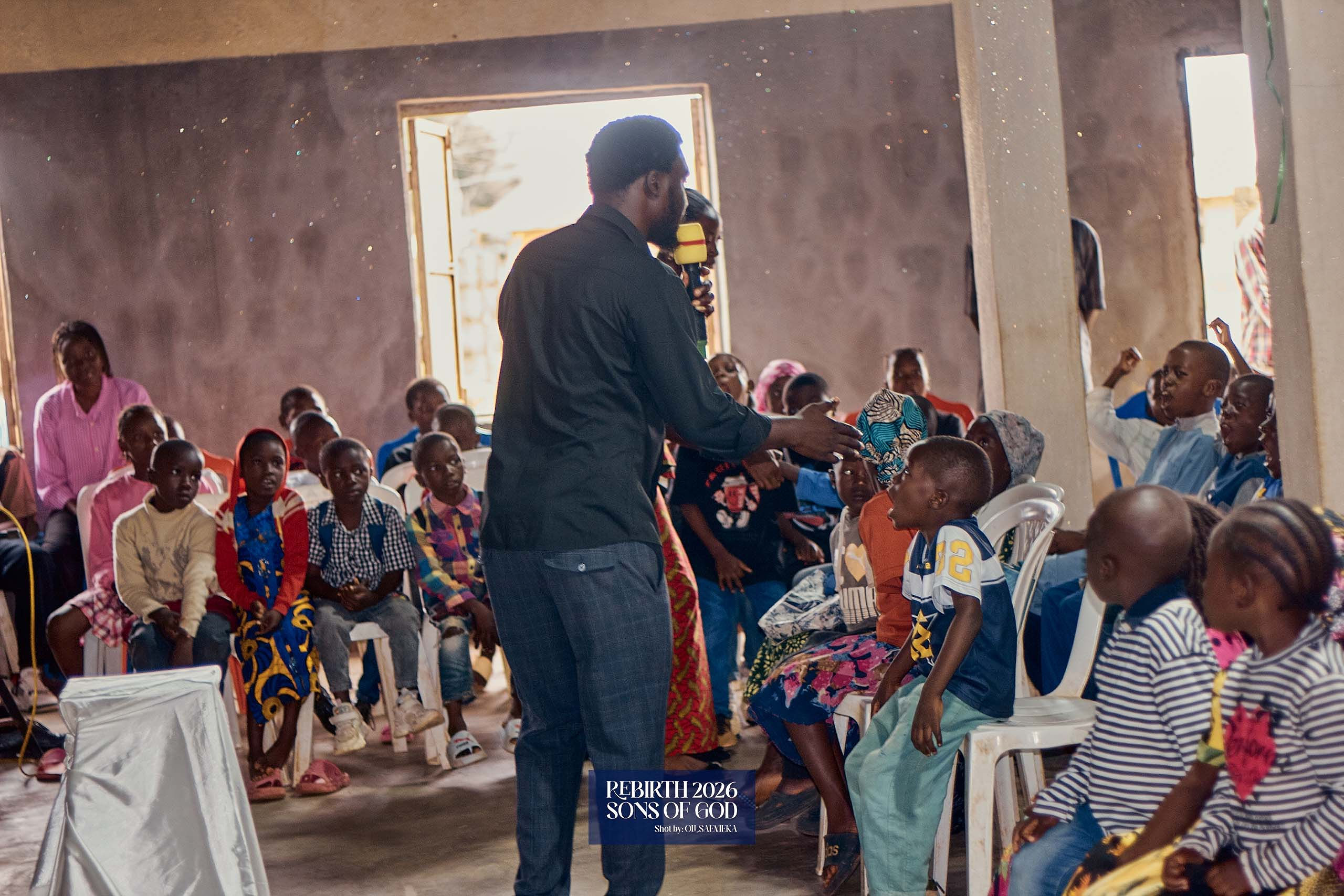 A leader speaking with children seated in a circle.