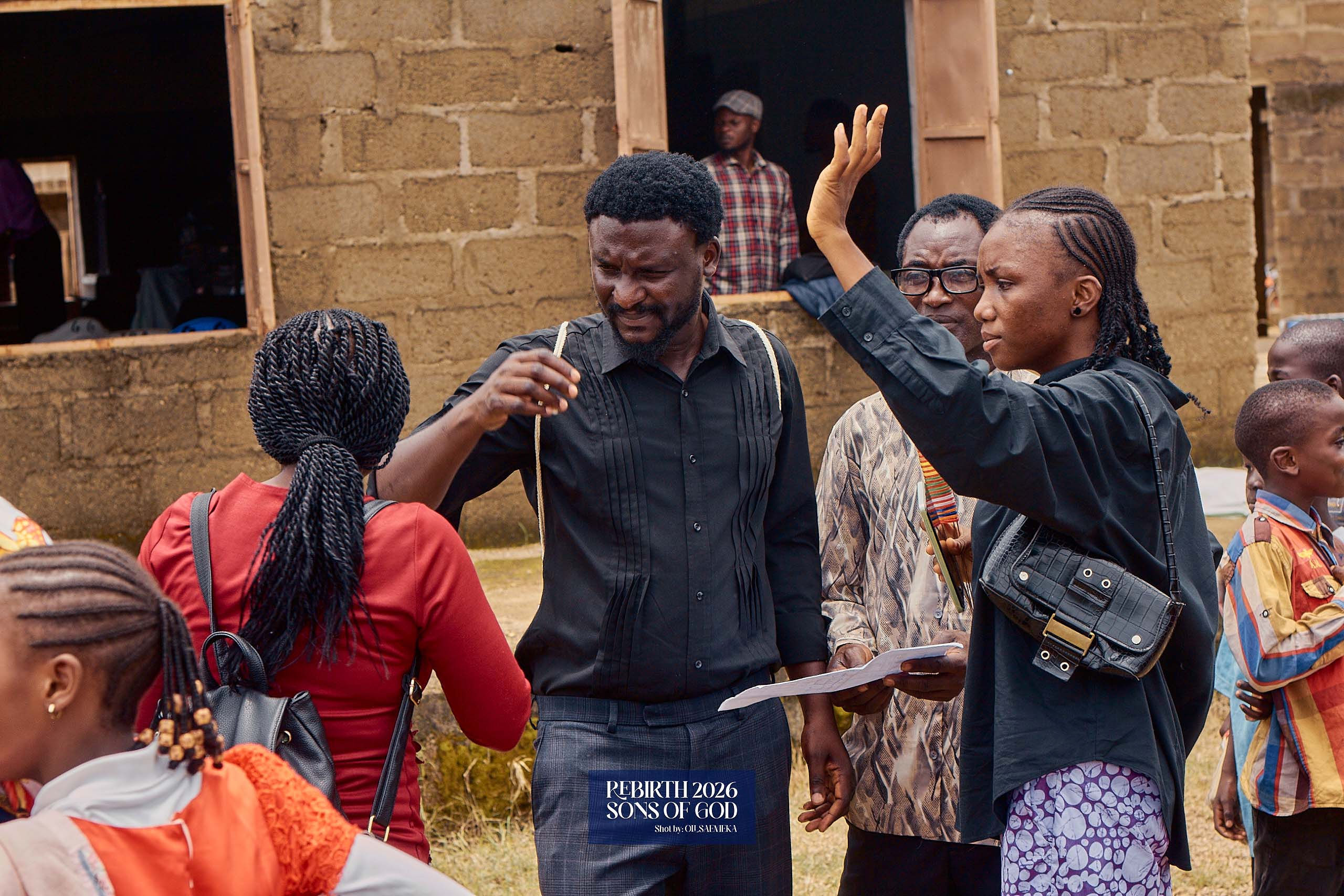 Adults talking together outside a building while holding papers.