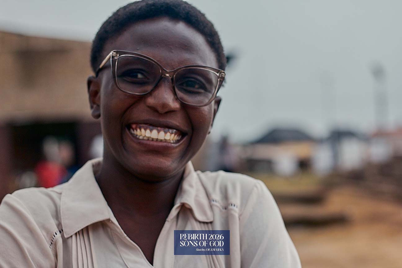 A smiling adult wearing glasses outside.