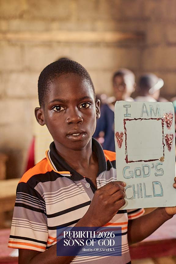 A child displaying a handmade card that reads I am God's child.