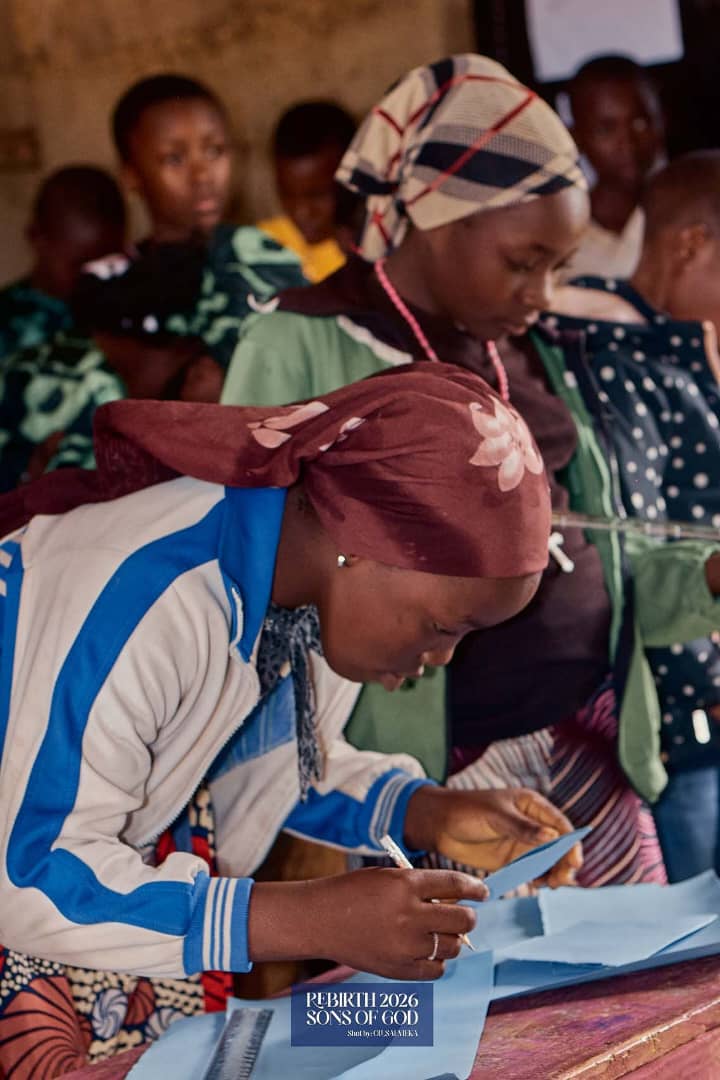 Children arranging and cutting paper at a classroom table.