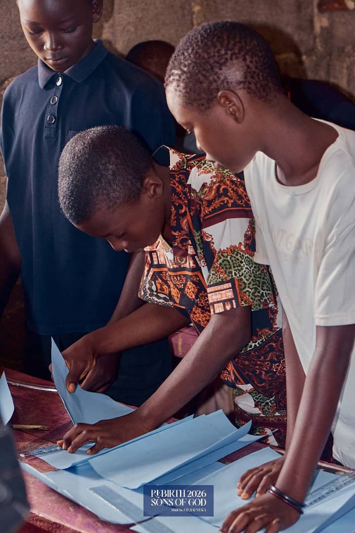 Children working with blue paper and a ruler.