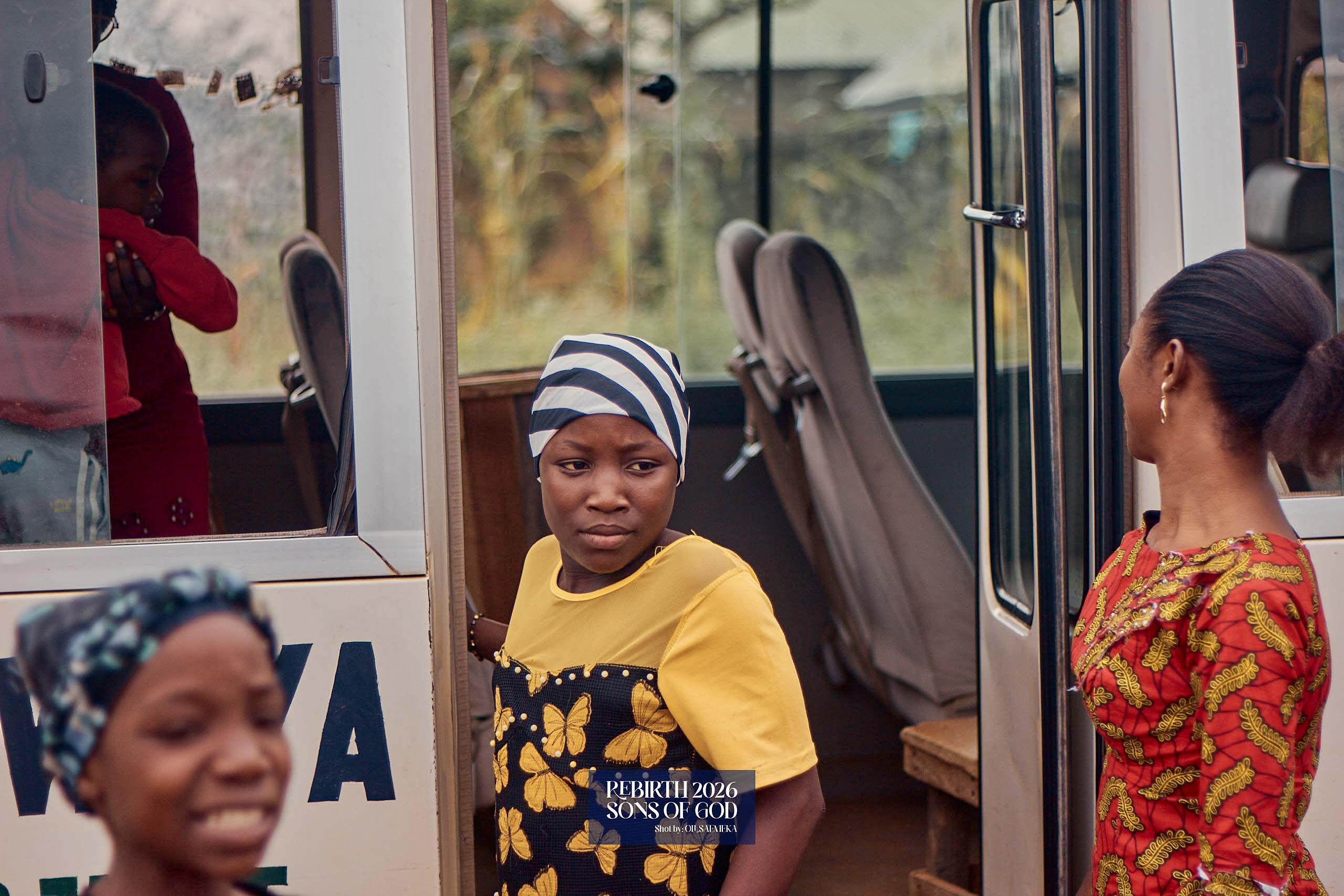 Children standing in and beside a bus doorway.
