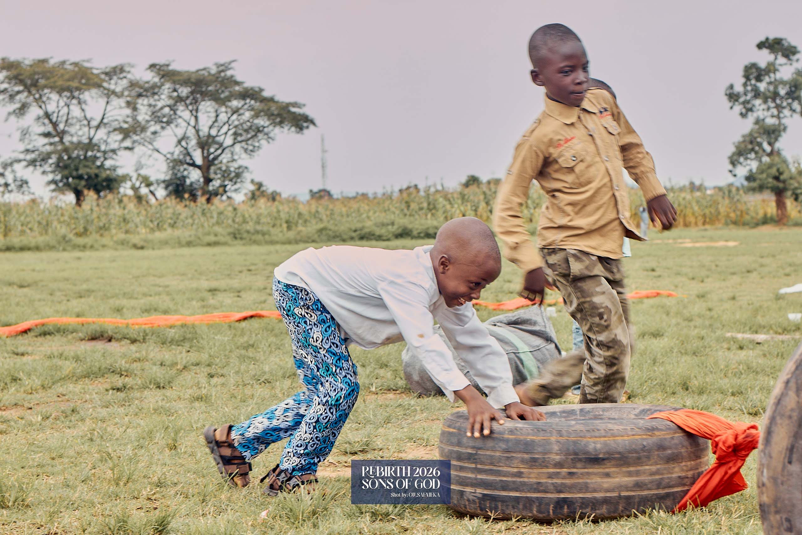 Two children taking part in an outdoor tyre game.